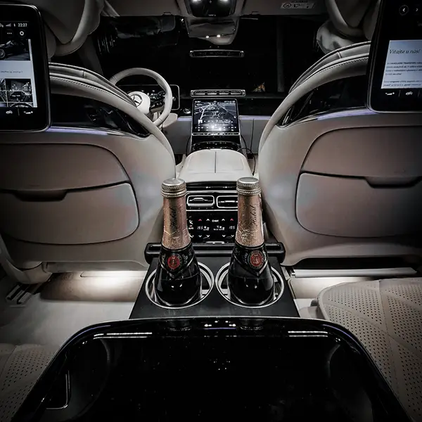 luxury mercedes benz s class white interior with champagne inserted in cupholder